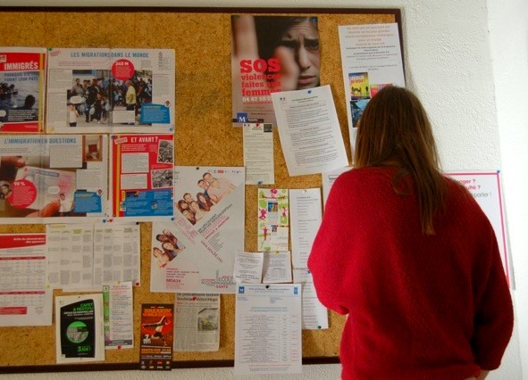 Une jeune fille prend connaissance des informations affichées sur le panneau dans les locaux du SAVA